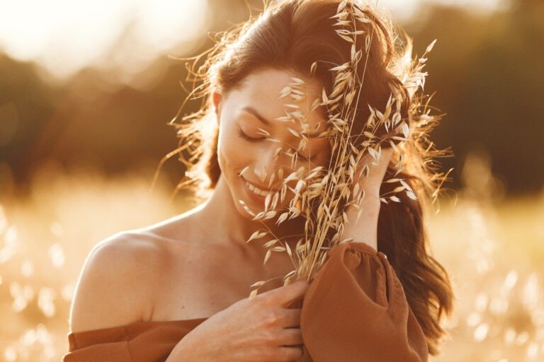 Woman in a summer field. brunette in a brown sweater